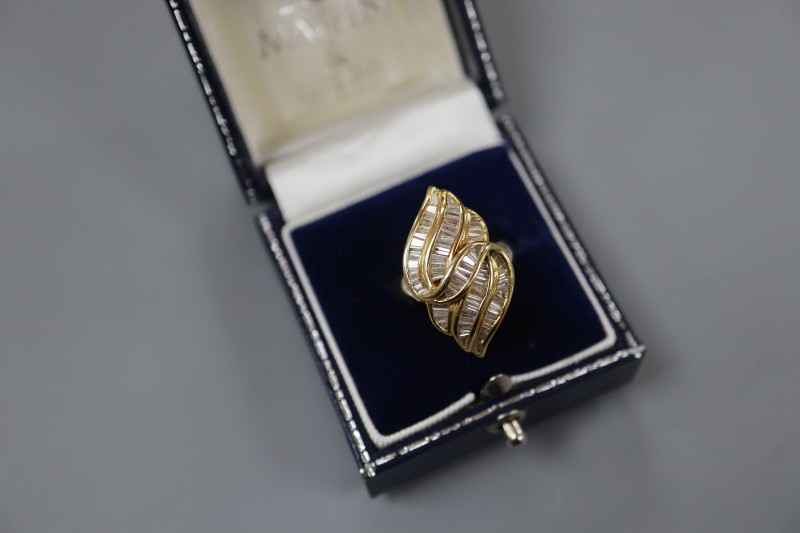 An 18k and trapeze cut diamond cluster set modernist dress ring, size L, gross 8.4 grams.